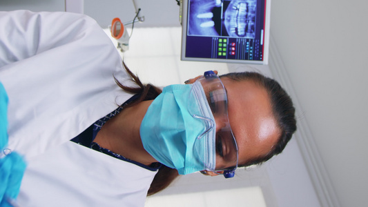 垂直视频牙科医生为病人做口腔避孕手术视频