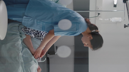 垂直视频在有呼吸道疾病时坐在床上的病人同时由医疗护士视频