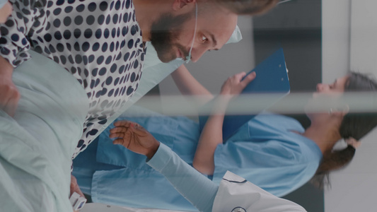 垂直视频病人在康复期间躺在床上时与医生讨论病情的纵向【竖版】视频