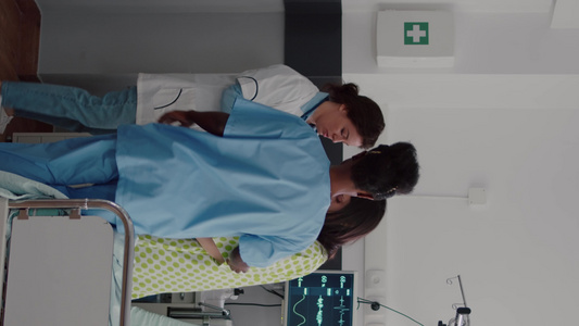 垂直视频美国护士与医生帮助病人从床上起立他带了医生视频