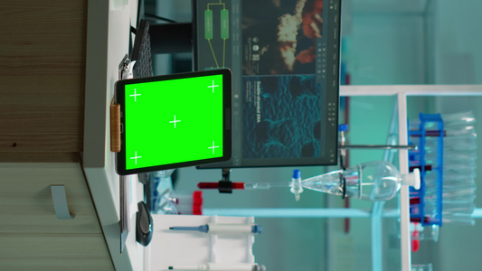 垂直视频放在实验室桌上的绿色染色体钥匙屏幕平板视频