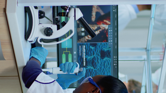 垂直视频黑人女性化学家分析显微镜上病毒的反应视频