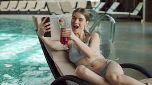 性感的女人在游泳池里打视频电话26秒视频