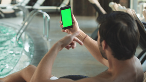 男人在泳池边打绿色屏幕电话视频12秒视频