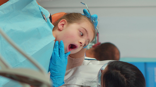 垂直视频向小女病人提供带面罩的儿科牙医牙齿治疗视频