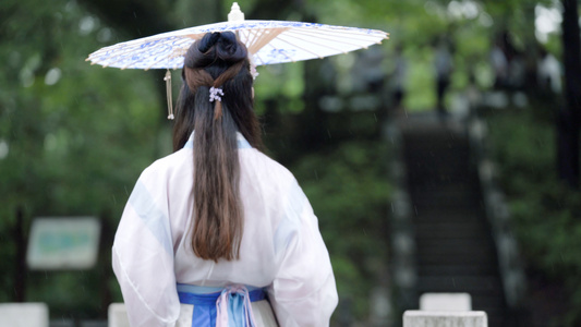 4k古风古装女性手拿油纸伞在雨中行走视频