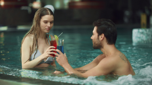 小情侣在豪华的泳池喝鸡尾酒视频