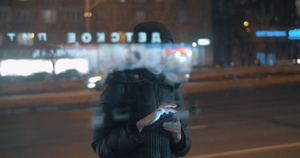晚上在城内等公交车时年轻妇女在网上上网10秒视频