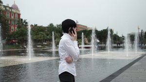 站在喷泉附近谈智能电话的有魅力的女人20秒视频