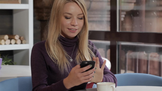 女孩在咖啡馆用智能手机视频