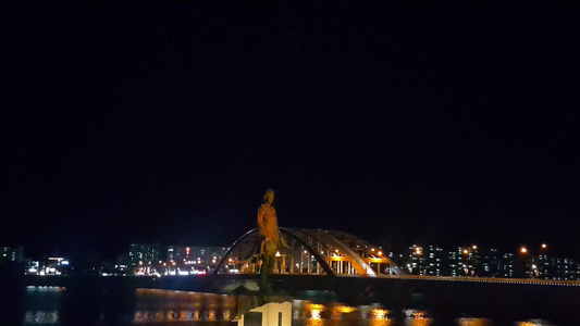 韩国城市夜景一尊美丽的雕像在海水上方视频