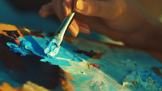 在画家调色板上搅拌颜料的女人画布上的油画[画者]视频
