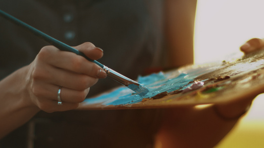 女性艺术家持有含油漆的肮脏调色盘视频