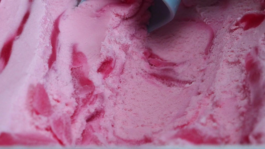 用勺子从容器里拿出冰淇淋草莓来放在前门看食物的概念视频