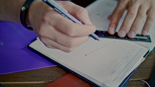 男性用手在笔记本上画草图用铅笔和标尺绘制人画线[手面]视频
