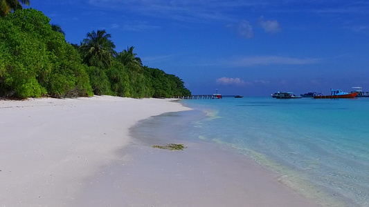 蓝绿色的大海和礁石附近的白色沙滩背景充满异国情调的视频