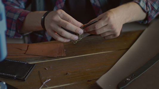 手工匠在家庭车间制造皮革钥匙链[匠们]视频