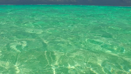 靠近冲浪的白色沙滩背景的蓝色海洋豪华海岸海滩度假的视频