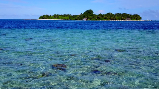 由水蓝色环礁湖和靠近度假胜地的浅沙背景所构成的阳光明媚视频