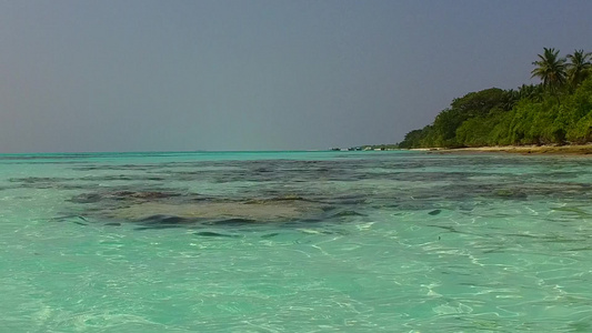 靠近礁石的白沙背景的蓝海豪华度假村海滩之旅的阳光海景视频