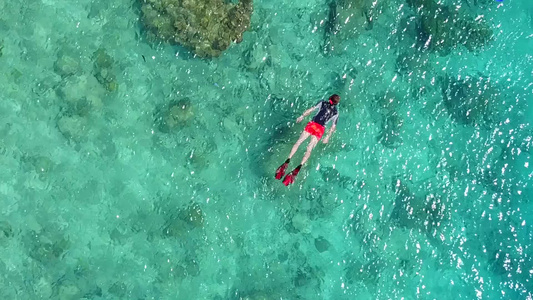 蓝海和冲浪附近的白色沙滩背景的豪华海滩度假日光全景视频