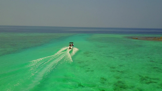在阳光下有白色沙子背景的蓝色海面上近距离接近完美的视频