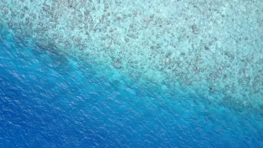 阳光明媚的宁静海岸海滩渡过蓝海冲浪附近有清洁沙滩背景视频