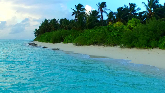 在阳光下的白色沙滩旁的蓝色清澈海洋视频