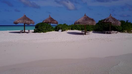 通过海浪附近的水蓝色海洋和白色沙滩背景展现完美的岛屿视频