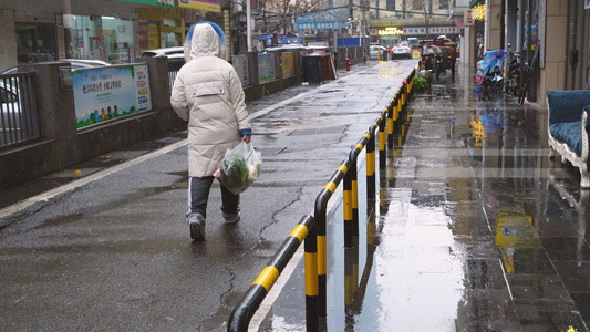 城市冒雪降温拎着塑料袋女性背影4k环保素材视频