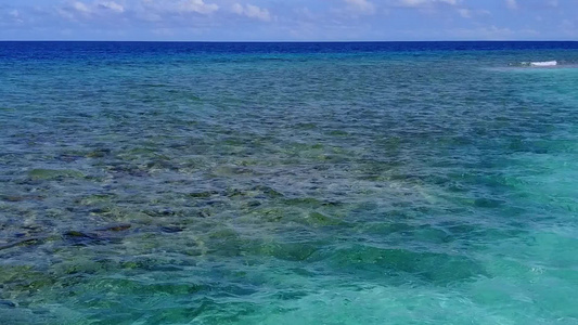 沿蓝绿色海洋和沙滩附近白沙地背景的浅海岸海滩航行时视频