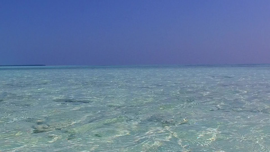 以水蓝色环礁湖和沙滩附近的浅沙土背景为例关闭海洋海岸视频