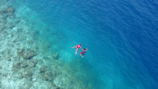 以蓝海和日落前的白沙底背景进行浪漫抽象的豪华环礁湖视频