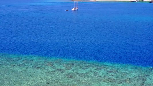 以蓝海和沙滩附近的白沙沙本背景进行完美海岸海滩航行视频