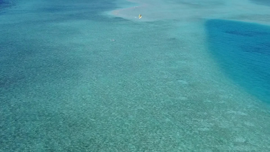 在珊瑚礁附近有白色沙滩背景的海平面蓝色海滨上漫游空空视频