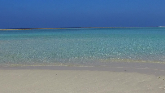 日落前蓝色环礁湖和白色沙滩背景的阳光明媚的海岸海滩视频