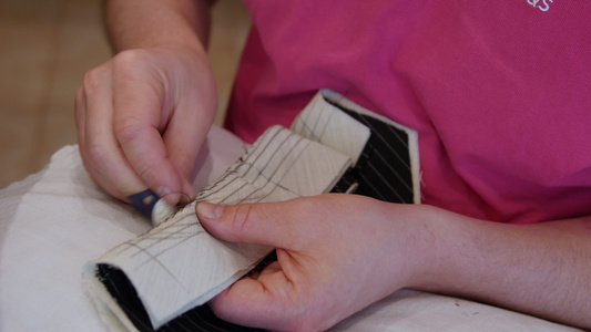 时装设计师用手垫缝衣衣领针针在一件定制夹克的下项圈视频