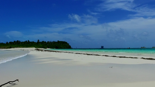 在阳光下的白色沙滩旁的蓝色清澈海洋视频