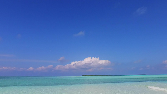 在沙滩附近由具有清洁沙土背景的蓝色水礁环礁湖进行海边视频