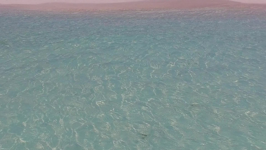 通过透明的水和接近冲浪的白色沙滩背景密切地环绕着热带视频