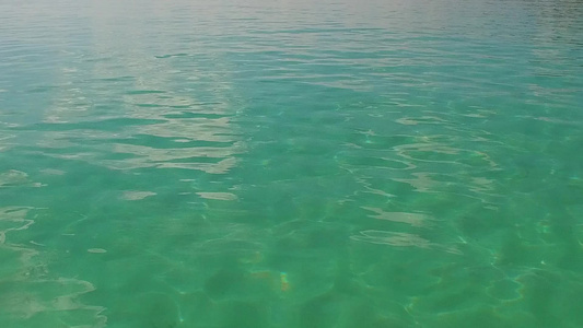 靠近海浪的明亮沙质背景的水蓝色泻湖进行完美旅游海滩视频