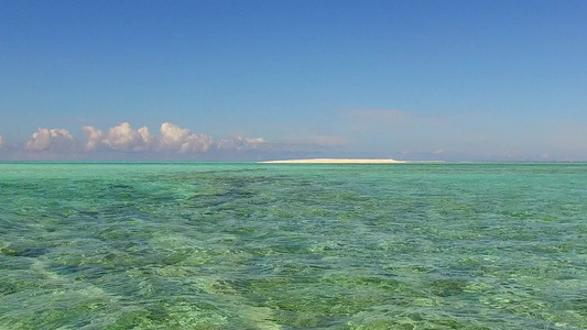 蓝色环礁湖和接近冲浪的白色沙滩背景所呈现的沿海海岸视频