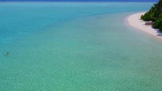 在阳光下蓝色的大海和白色的沙滩背景近距离欣赏放松的视频