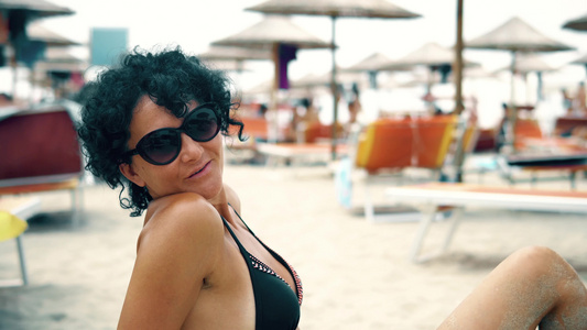 带眼镜的美女在沙滩上享受暑假对着镜头微笑视频
