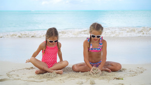 可爱的小女孩在沙滩上玩得很开心两个漂亮的孩子在海边10秒视频