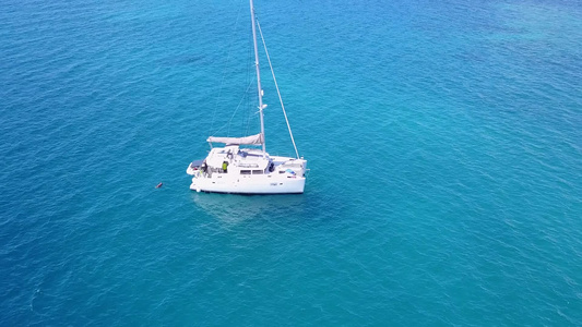 在度假胜地附近以蓝色水和白色沙沙底背景航行的海滨上视频