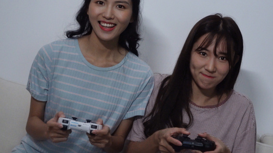 4k两个女生使用游戏手柄在打电子游戏视频