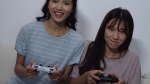 4k两个女生使用游戏手柄在打电子游戏21秒视频