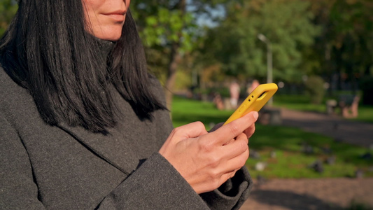 女性在户外拥有智能手机的近身细节视频