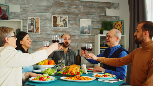 午餐烤红酒时快乐的家庭周日晚餐时朋友和家人一起吃晚饭视频